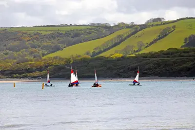 four sailboats in the water with a hill in the background at Seascape in New Quay