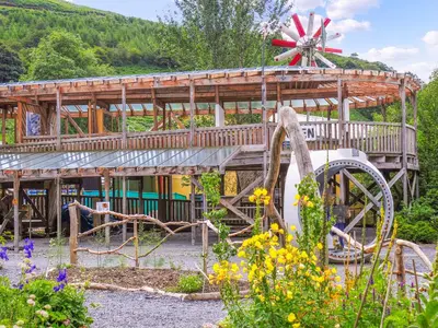 a wooden house with a garden with flowers at Bryn Araul in Rhydymain
