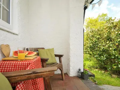a table with a plate of watermelon on a patio at Bryn Araul in Rhydymain