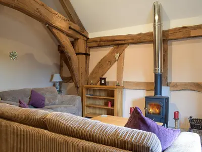 a living room with a couch and a wood stove at The Granary in Kingsland