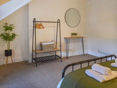 a bedroom with a green bed and a mirror at Ty Ni in Bala