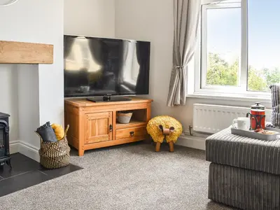 a living room with a large flat screen tv at Bryn Derwen in Harlech