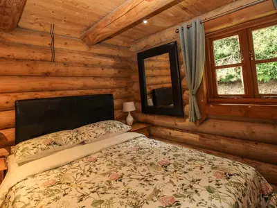 a bedroom with a bed in a log cabin at Brynallt Country Park in Ellesmere