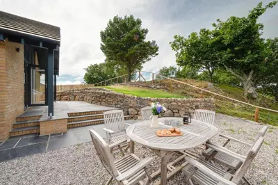 a patio with a table and chairs and stairs at 3 Bed in Barmouth oc-wah701 in Barmouth