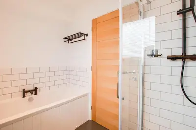 a bathroom with a shower and a tub and a sink at 3 Bed in Barmouth oc-wah701 in Barmouth