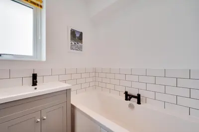 a white bathroom with a tub and a sink at 3 Bed in Barmouth oc-wah701 in Barmouth