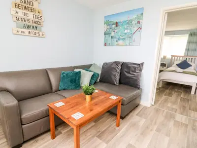 a living room with a couch and a table at Cwtsh Cragen in New Quay