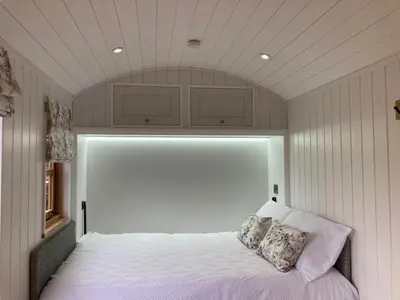 a bedroom with a white bed with two pillows on it at The Snug at Coed Y Gaer in Oswestry