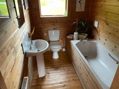 a bathroom with a toilet and a tub and a sink at Luxury 3 bedroom, 3 bathroom lodge with hot tub in Llanbedr