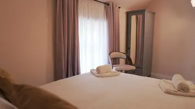 a bedroom with a bed with a mirror and a chair at Meadow Terrace in Shrewsbury