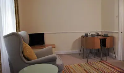 a living room with a table and a chair at Meadow Terrace in Shrewsbury