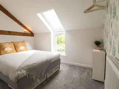 a bedroom with a bed and a window at Little Nook in Corwen