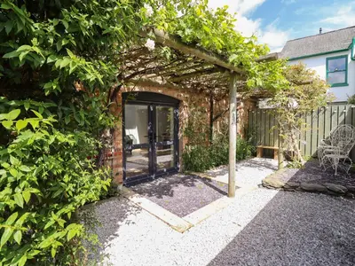 an entrance to a brick house with an open door at Little Nook in Corwen