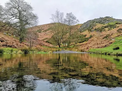 a body of water with mountains in the background at Romantic Croft with Private Hot Tub in Shrewsbury