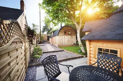a backyard with two chairs and a fence at Romantic Croft with Private Hot Tub in Shrewsbury