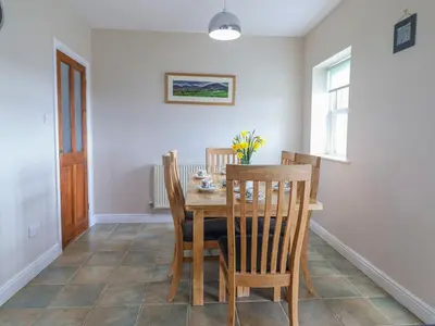 a dining room with a wooden table and chairs at Ty Cerrig in Dyffryn
