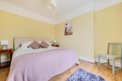 a bedroom with a bed with a purple blanket and a chair at 3 Bed in Bethlehem oc-waw219 in Llangadog