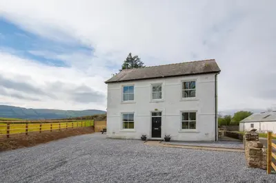 a white house on a gravel road with a fence at 3 Bed in Bethlehem oc-waw219 in Llangadog