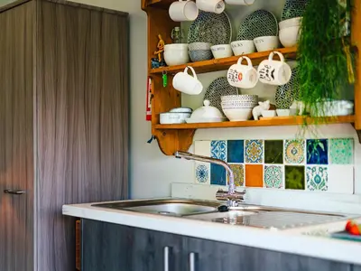 a kitchen with a sink and a shelf with cups at Cwtch Enrico - Uk39064 in Scyborycoed