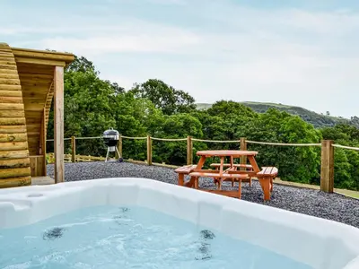 a hot tub and a picnic table on a patio at Mountain View - Uk34179 in Cilycwm
