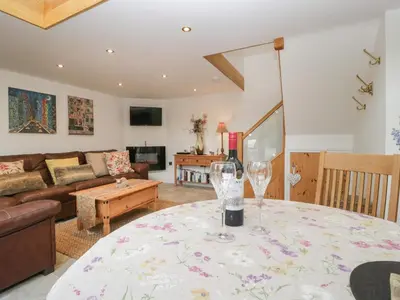 a living room with a table with a wine glass at The Cart Barn in Leominster