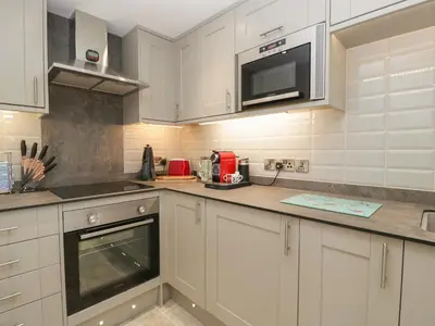 a kitchen with white cabinets and a microwave at The Cart Barn in Leominster