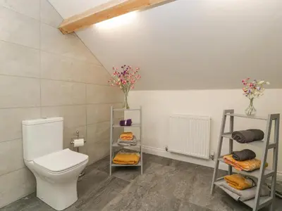 a bathroom with a toilet and some shelves at The Cart Barn in Leominster