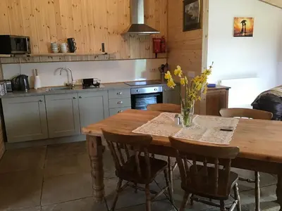 a kitchen with a wooden table with a vase of flowers on it at 1 Bed Lodge-Sleeps 4-Pet Friendly-Free Parking in Hereford