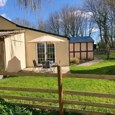 a house with a table with an umbrella and a fence at 1 Bed Lodge-Sleeps 4-Pet Friendly-Free Parking in Hereford