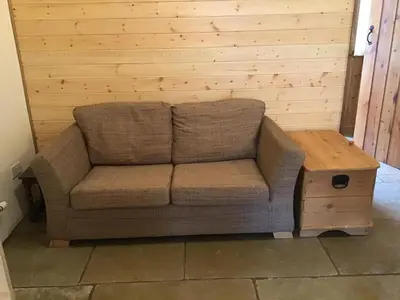 a brown couch sitting in a room with a wooden table at 1 Bed Lodge-Sleeps 4-Pet Friendly-Free Parking in Hereford