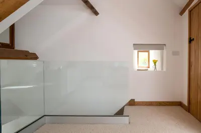 a room with white walls and a window and a staircase at Snowdonia Holiday Cottage in Bala