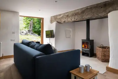 a living room with a blue couch and a fireplace at Snowdonia Holiday Cottage in Bala