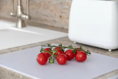 a bunch of tomatoes on a cutting board on a sink at Snowdonia Holiday Cottage in Bala