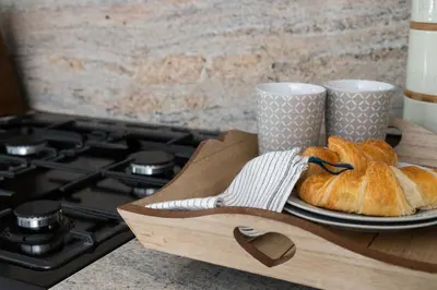 a wooden tray with a plate of bread and two cups at Snowdonia Holiday Cottage in Bala