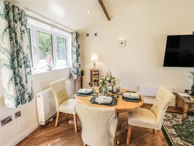 a dining room with a table and chairs and a tv at Fairfield in Ludlow