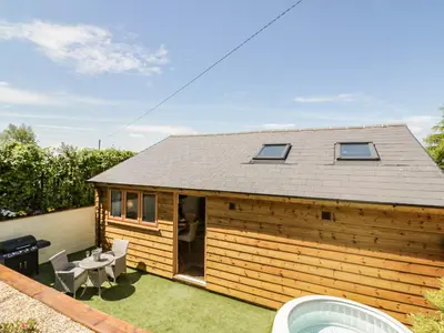 a small house with a patio with a table and chairs at Fairfield in Ludlow