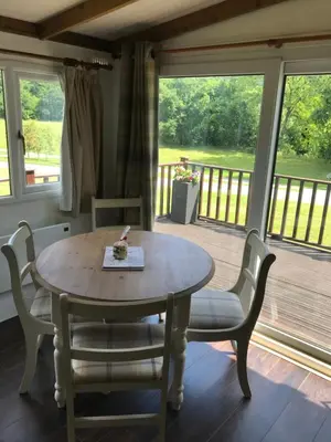 a dining room with a table and chairs on a porch at Pheasant Lodge in Builth Wells
