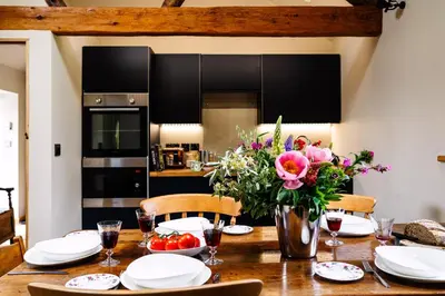 a dining room table with flowers and plates on it at Romantic Snowdonia Cottage with Hot tub, sea & mountain views in Tywyn
