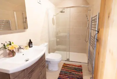 a bathroom with a sink and a toilet and a shower at Romantic Snowdonia Cottage with Hot tub, sea & mountain views in Tywyn