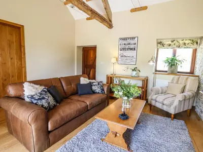a living room with a brown couch and a table at Golwg Las in Llanwrda