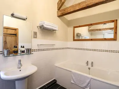 a white bathroom with a sink and a mirror at Golwg Las in Llanwrda