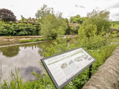 a sign next to a river with a pond at 2 The Villa in Ludlow