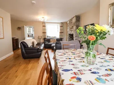 a living room with a table with a vase of flowers on it at Artro View in Llanbedr