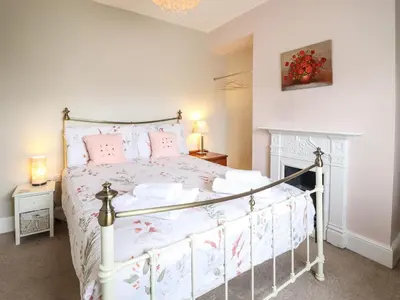 a bedroom with a white bed with pink pillows at Artro View in Llanbedr