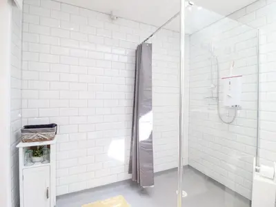 a bathroom with a shower with white tiles at Varley Villa in Newtown
