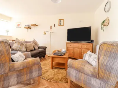 a living room with two couches and a flat screen tv at Varley Villa in Newtown