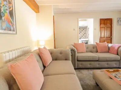 a living room with two couches and a table at The Old Smithy Cottage in Blaenau-Ffestiniog