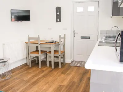a kitchen with a table and chairs and a door at Little Oakleigh in Llanymynech