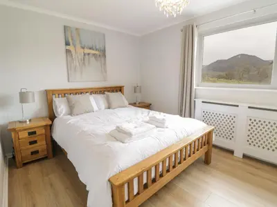 a bedroom with a large bed and a window at Bryn Teg in Oswestry