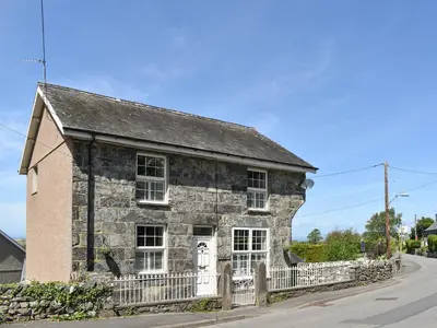 an old stone building with a white door at Bryn Y Felin in Dyffryn